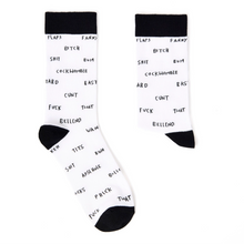 Load image into Gallery viewer, A pair of white crew socks with black cuffs, heels, and toes, featuring a black hand-drawn style text pattern of profane words and names like 'BELLADO', 'BITCH', and 'CUNT'.
